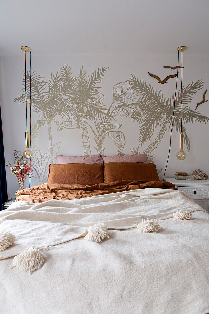 Bedroom with palm tree mural, bed and pendant lights