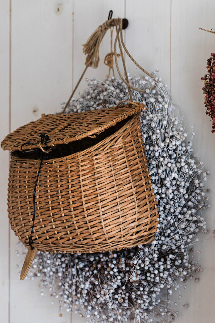 Basket and dried flowers on wall hooks