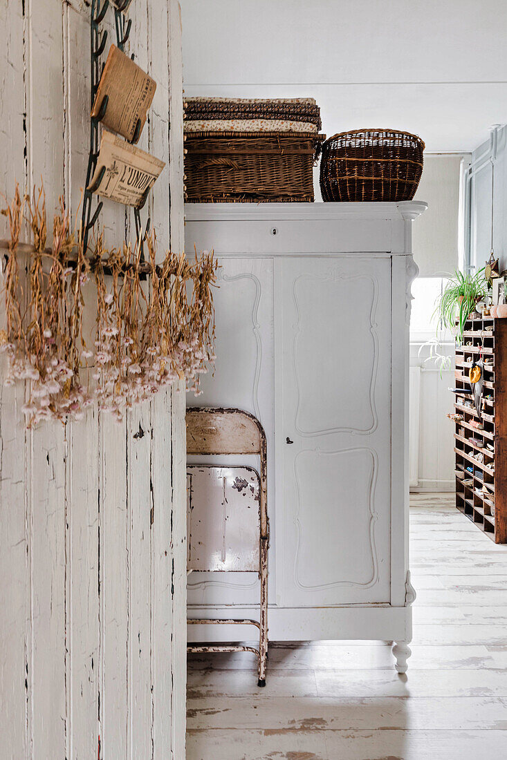 Vintage cupboard with wicker baskets in country house hallway