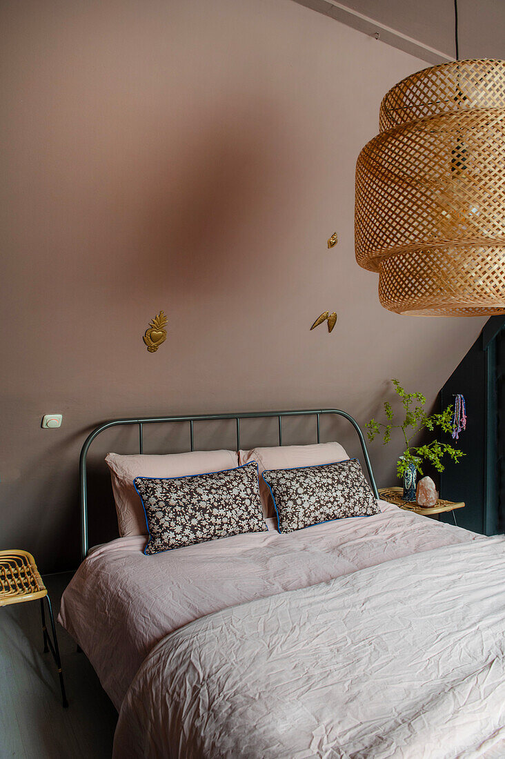 Bedroom with metal bed and large rattan ceiling lamp