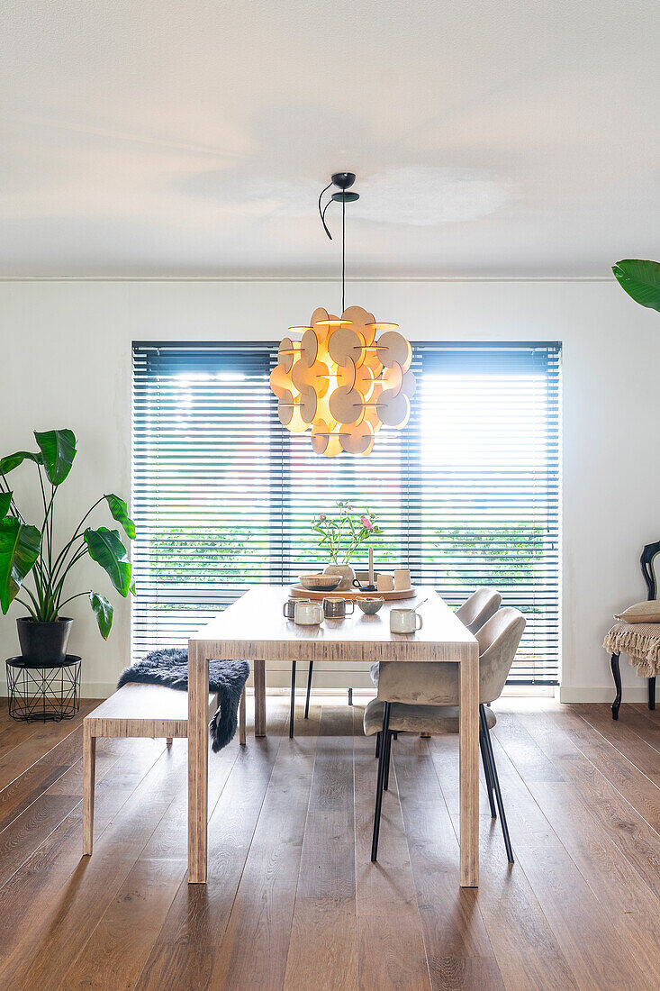 Dining area with wooden floor, plant and modern pendant light