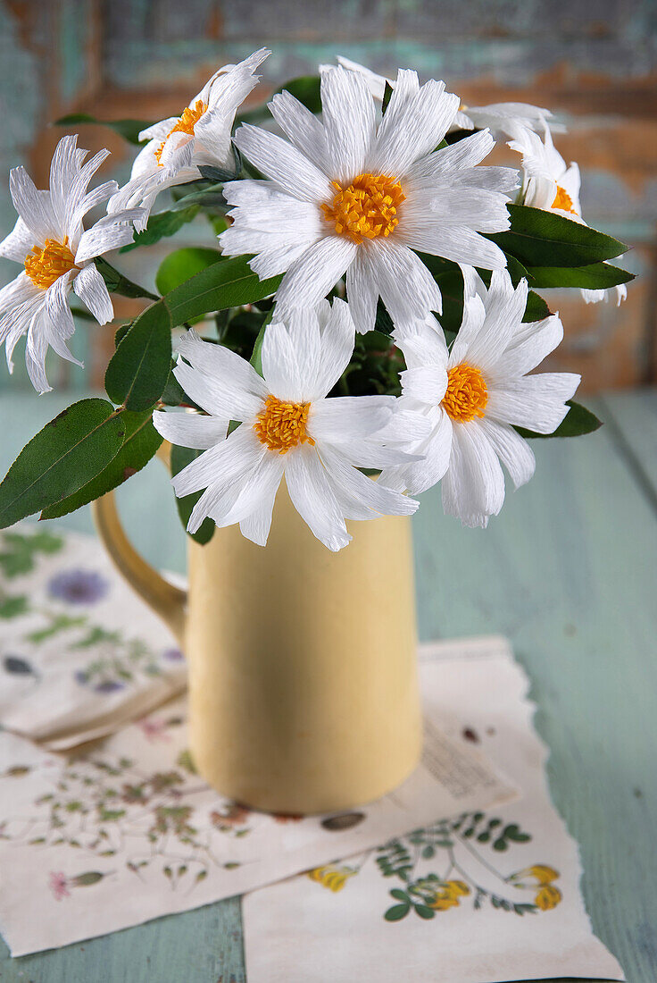 DIY-Blumen aus Papier in gelber Vase auf Pflanzenbildern