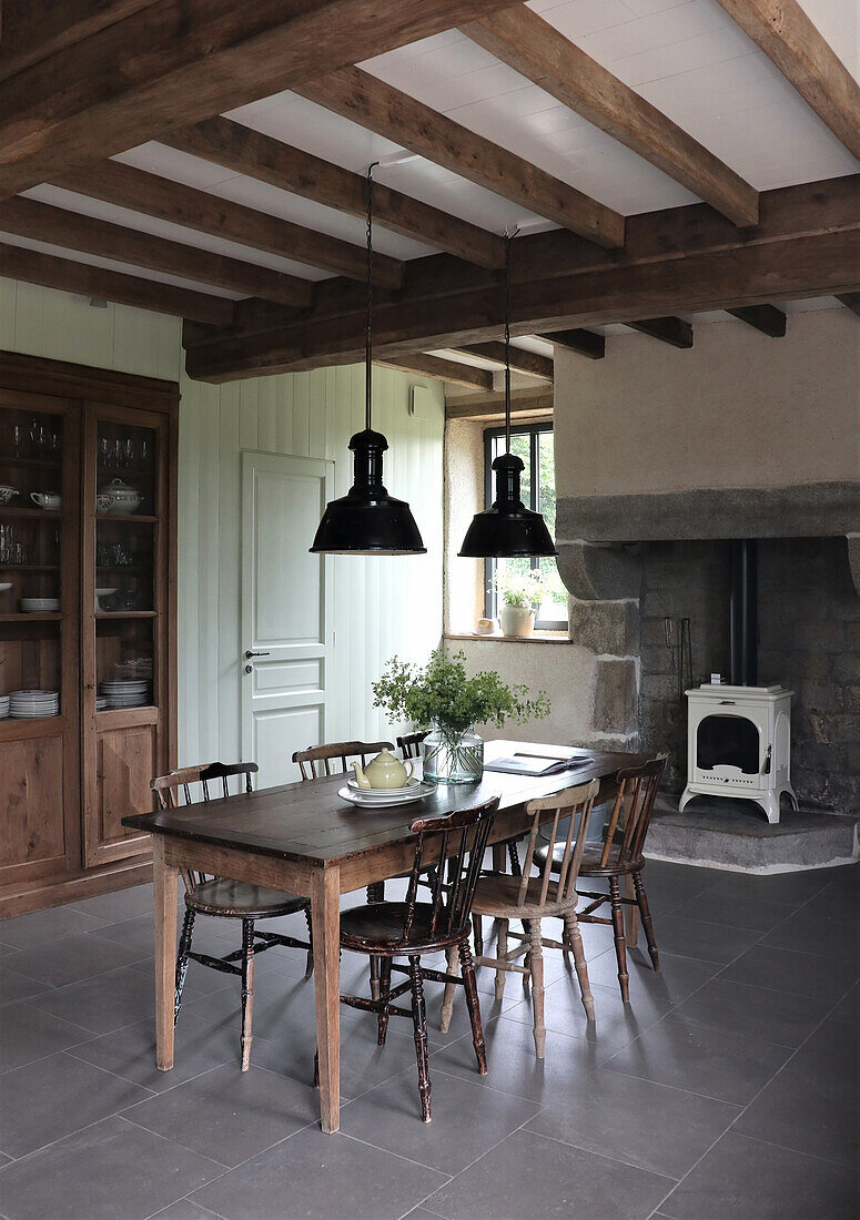 Country-style dining room with wooden table and wood-burning stove