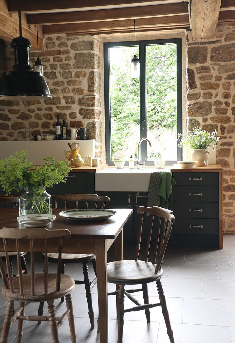 Küche im Landhausstil mit Natursteinwand und Holzmöbeln