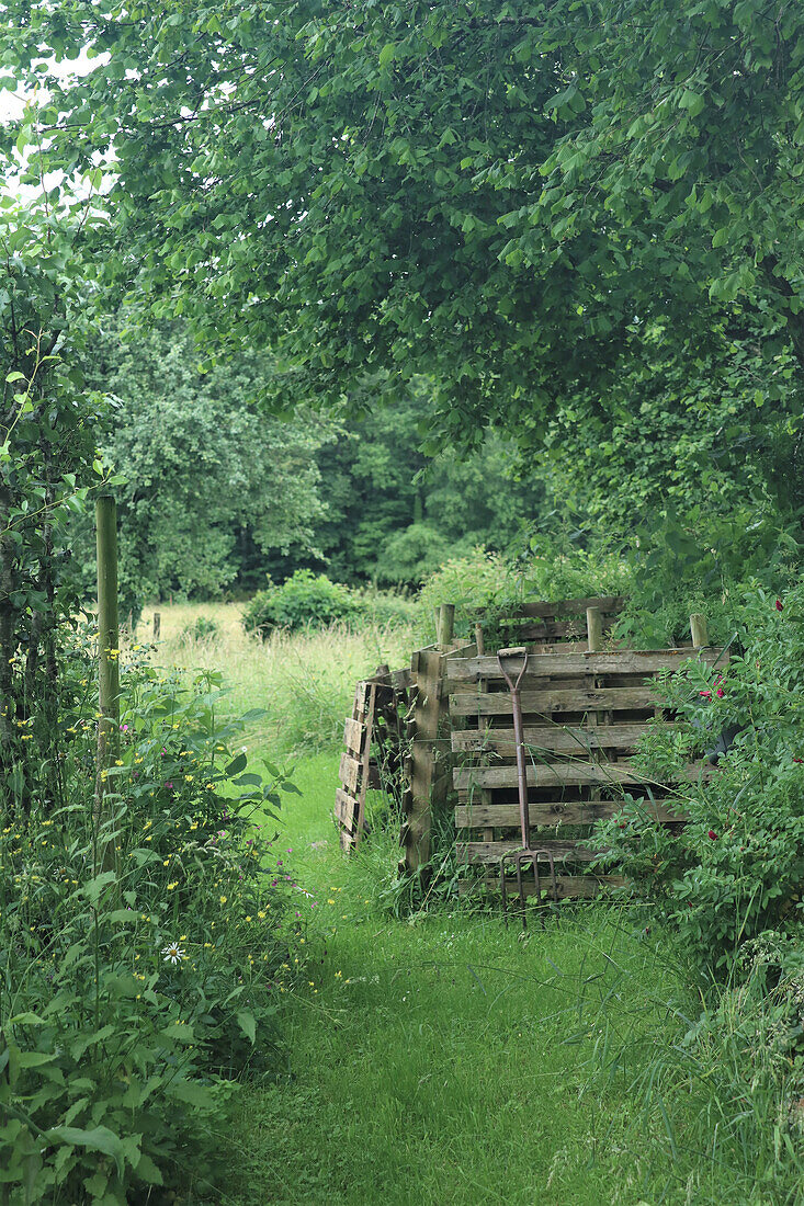 Composter made from wooden pallets, green garden path