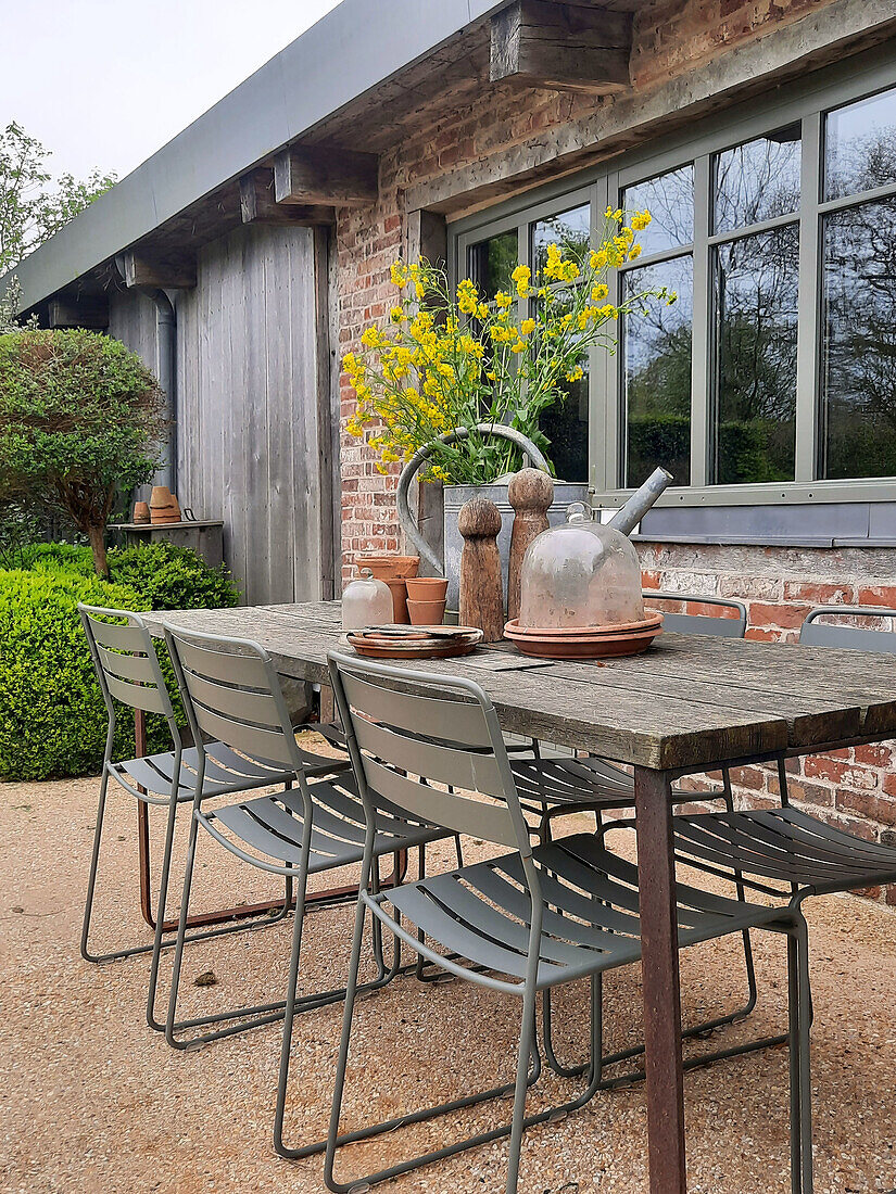 Rustic patio table with metal chairs and flower arrangement