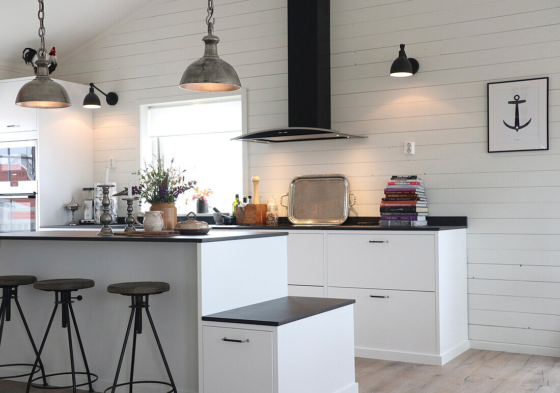 Modern kitchen with white wooden walls and black worktop