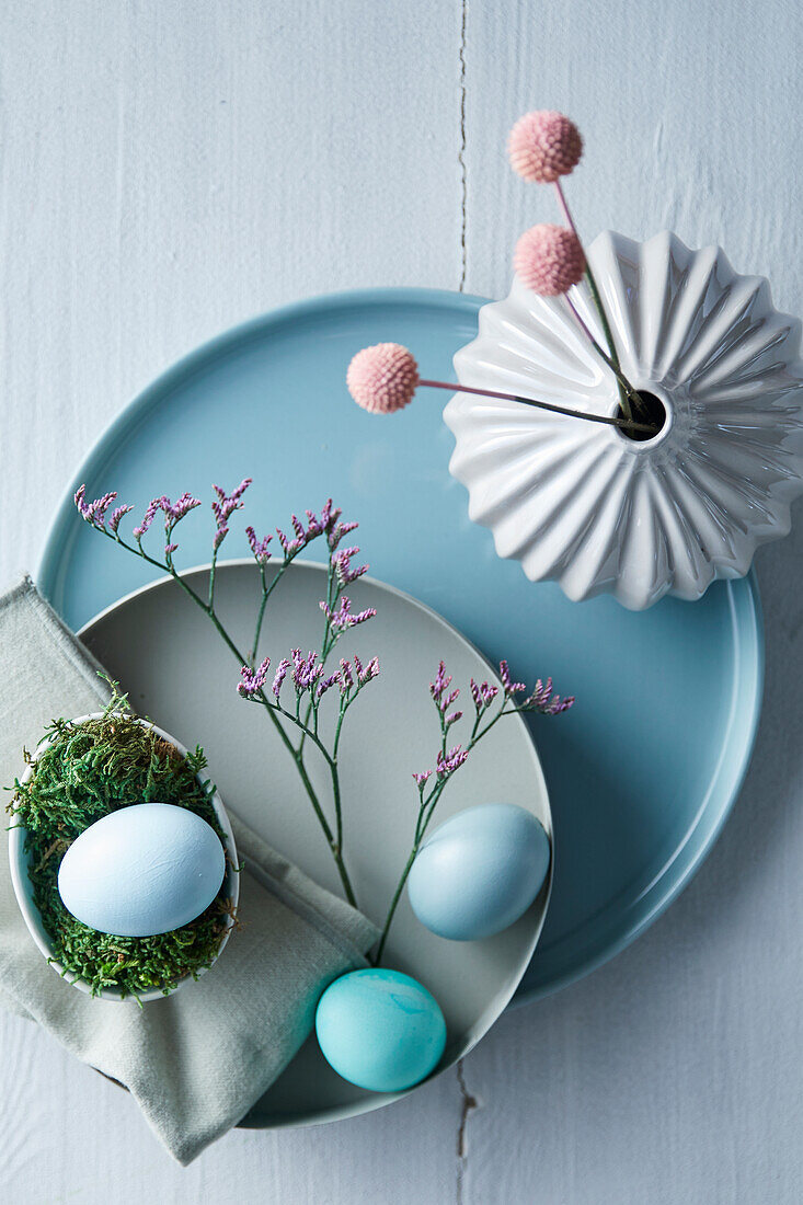 Minimalist Easter table setting with colored eggs and dried flowers