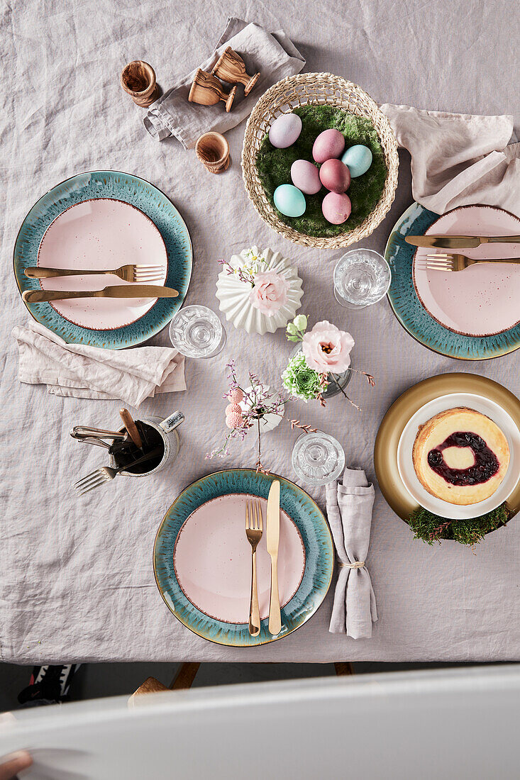 Easter table setting with pastel-colored eggs and flower arrangement