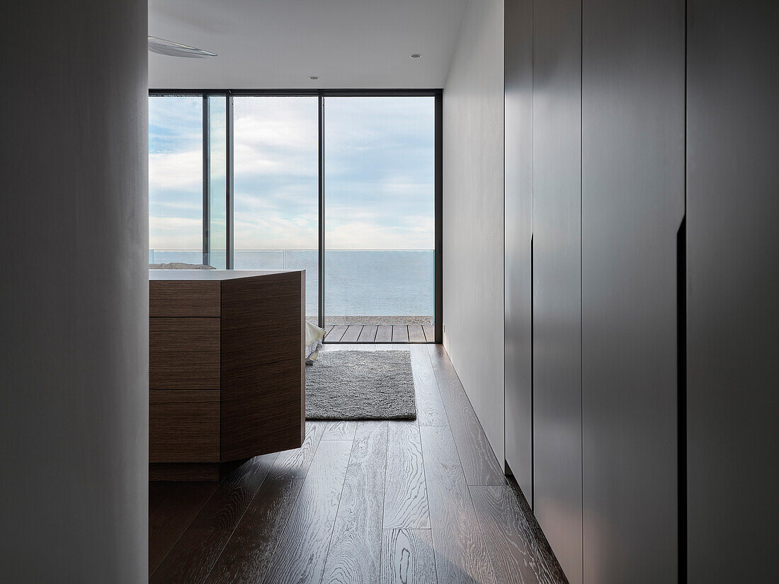 Wooden floor and large glass window front in room with sea view