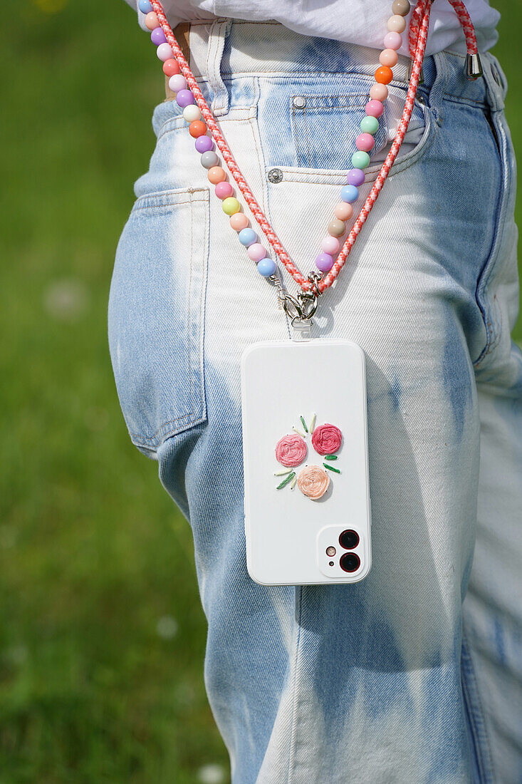 Smartphone with embroidered case and mobile phone chain with colourful beads