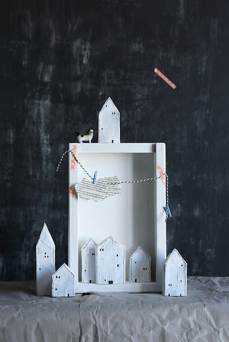 Small houses made from toilet paper rolls and book pages as Christmas decorations