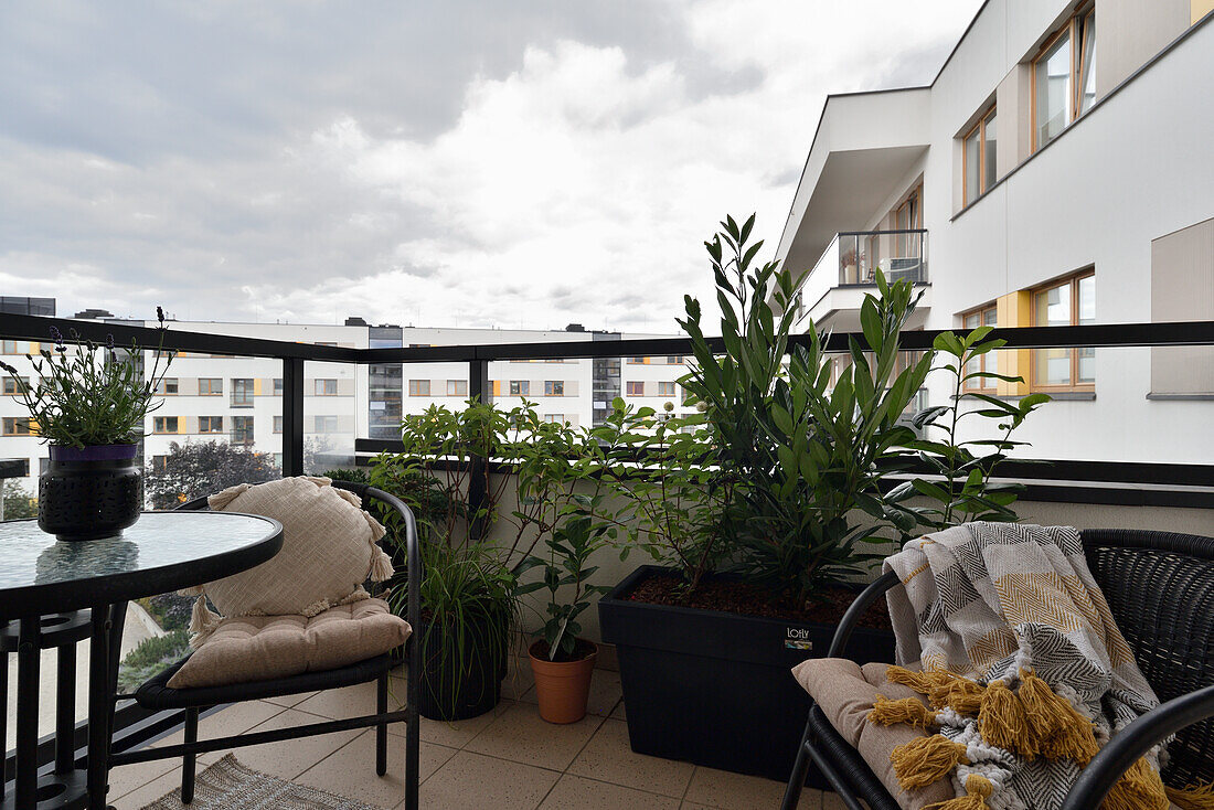 Cozy balcony with plants and seating in a modern apartment complex