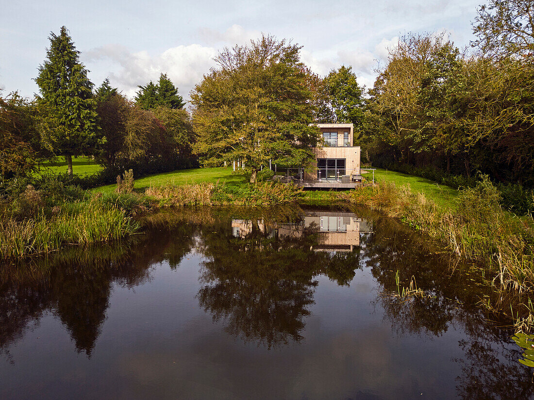 Modernes Einfamilienhaus mit Holzverkleidung und Aluminiumfenstern am Teich in Lincolnshire, UK