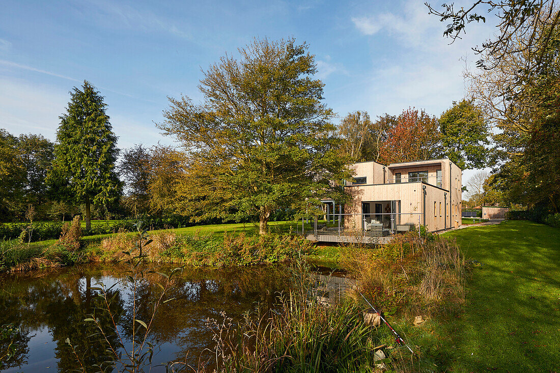 Modernes Einfamilienhaus mit Holzverkleidung und Teich im Garten, Scawby Brook, England