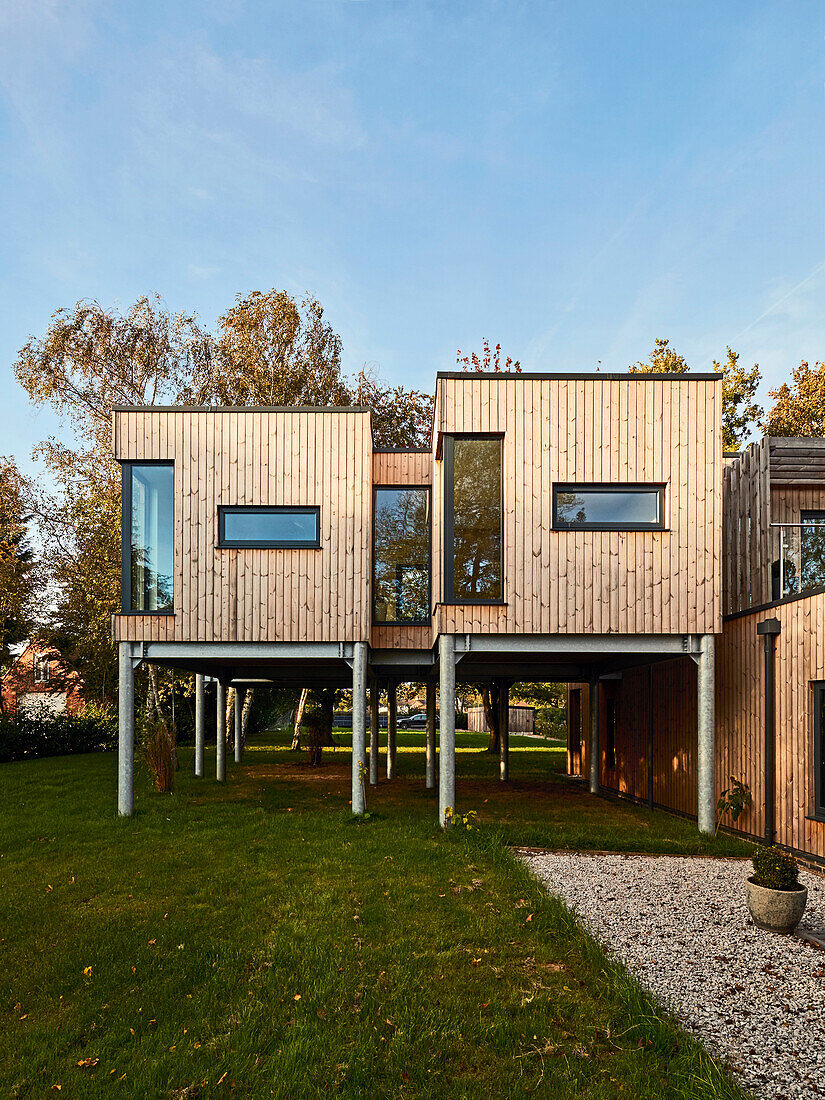 Modern wooden house on stilts in a spacious garden