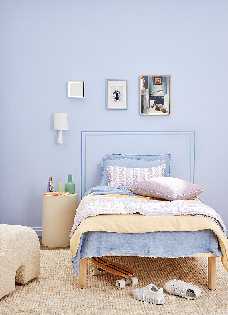 Bedroom with lilac-coloured wall, single bed and skateboard