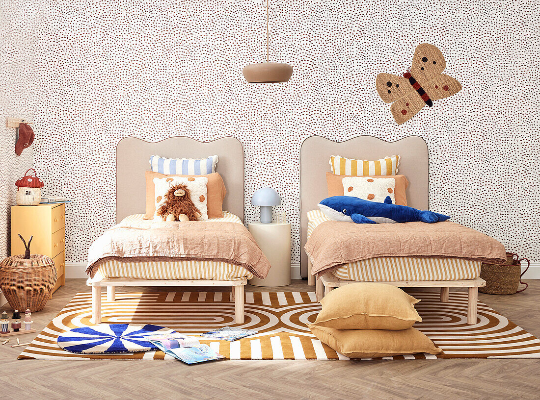 Children's room with two beds, patterned carpet and butterfly decorations