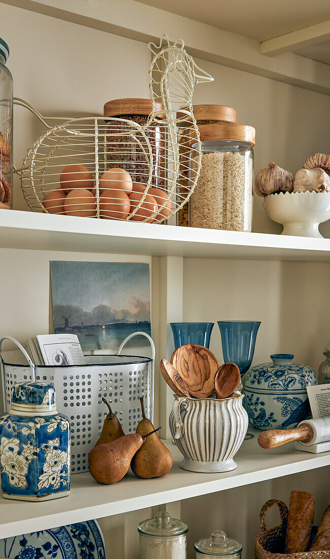 White shelf with storage jars, ceramics and kitchen utensils