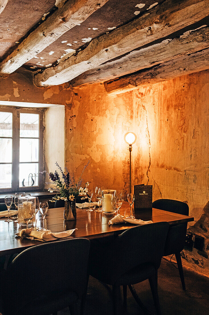 Rustic dining room with low wooden beamed ceiling and dim lighting