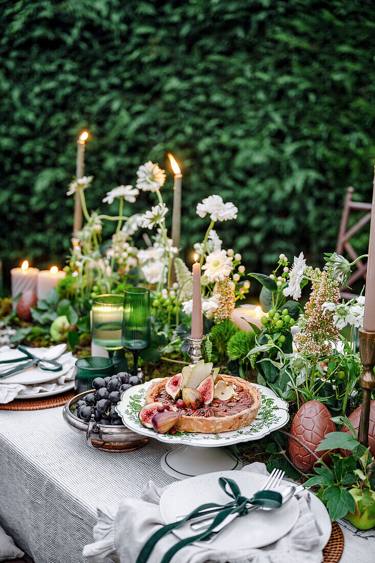 Festively laid garden table with fresh flower arrangements for Easter