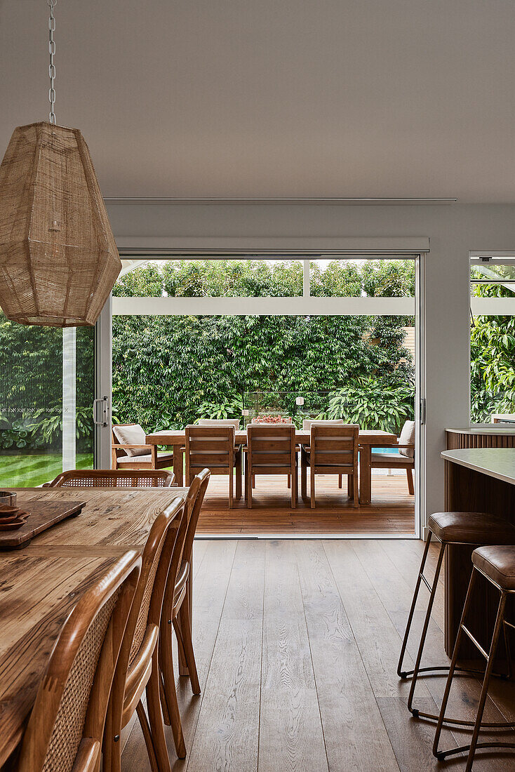 Open-plan living and dining area with a view of the green terrace