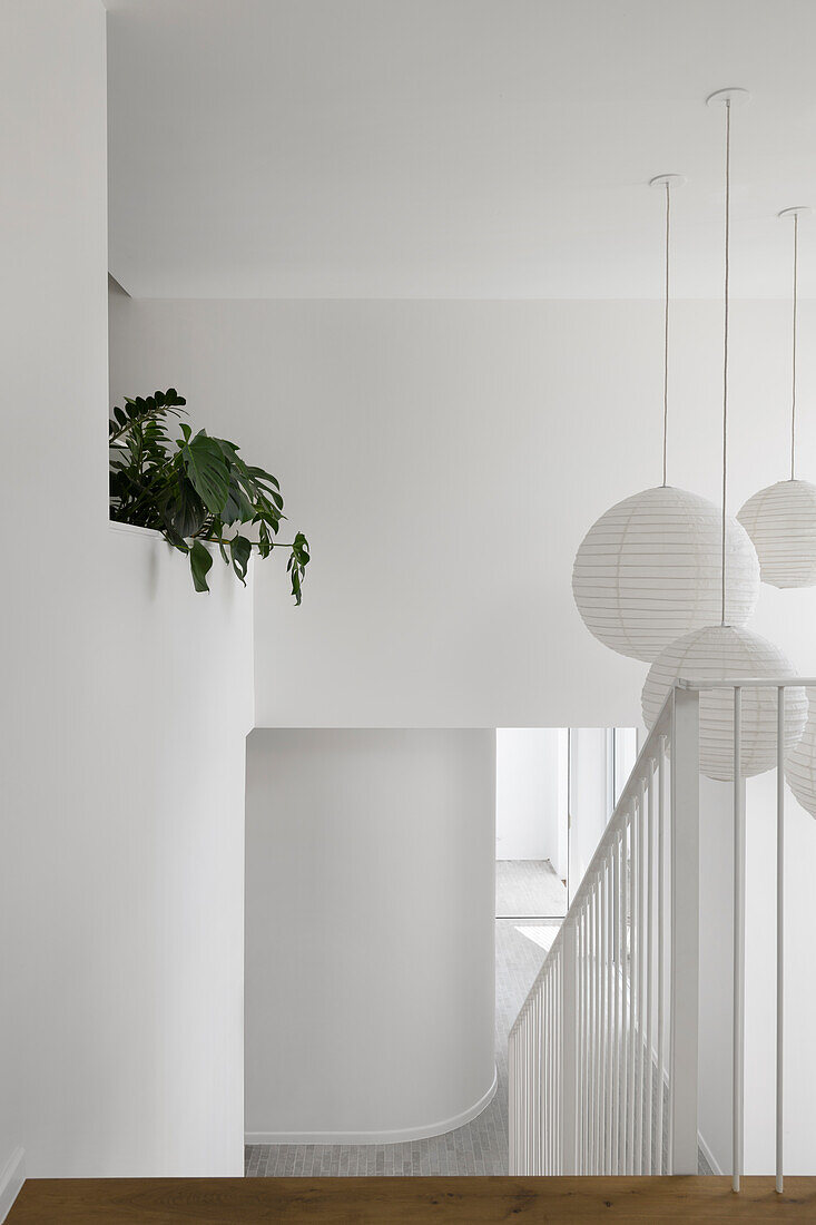 Modern staircase with white paper lamps and plants