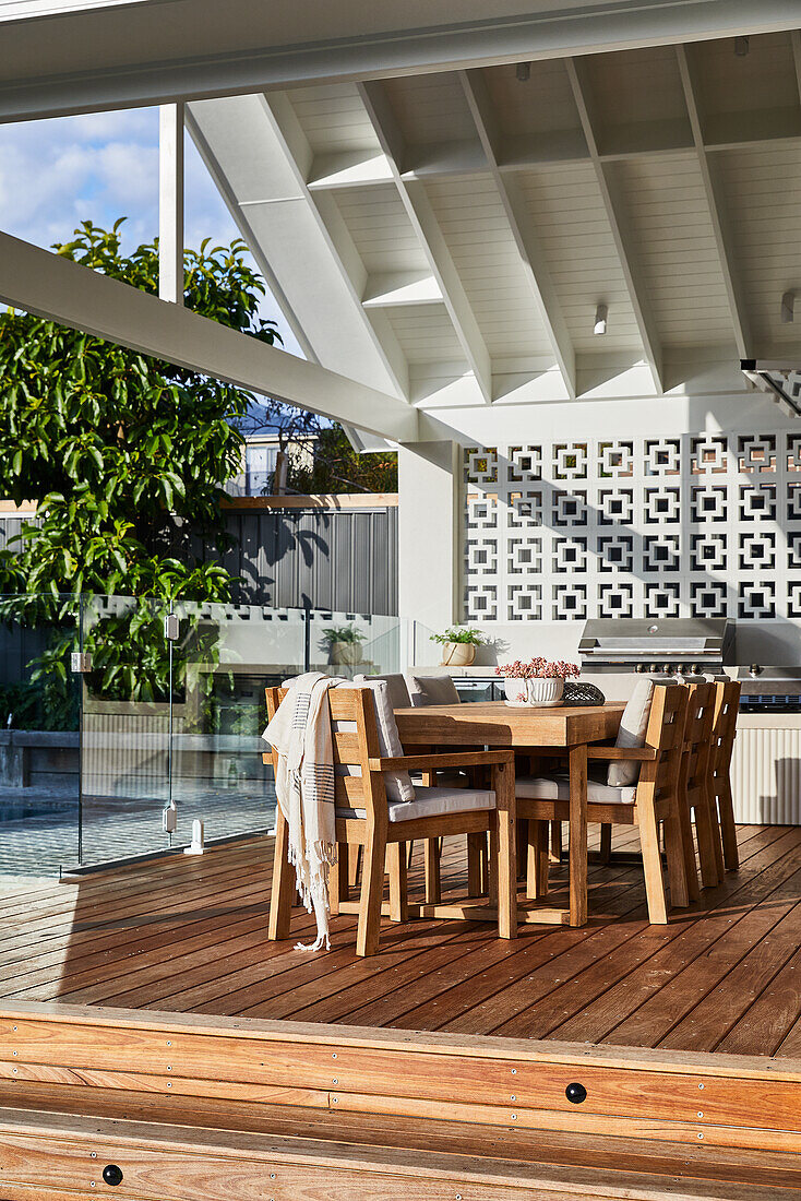 Modern terrace with wooden furniture and decorative privacy wall