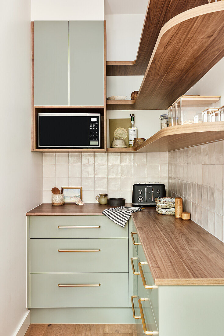 Kitchen with green cabinets and wooden worktop