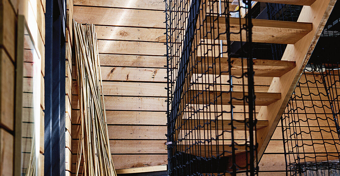 Holztreppe mit Drahtgeländer in modernem Interieur