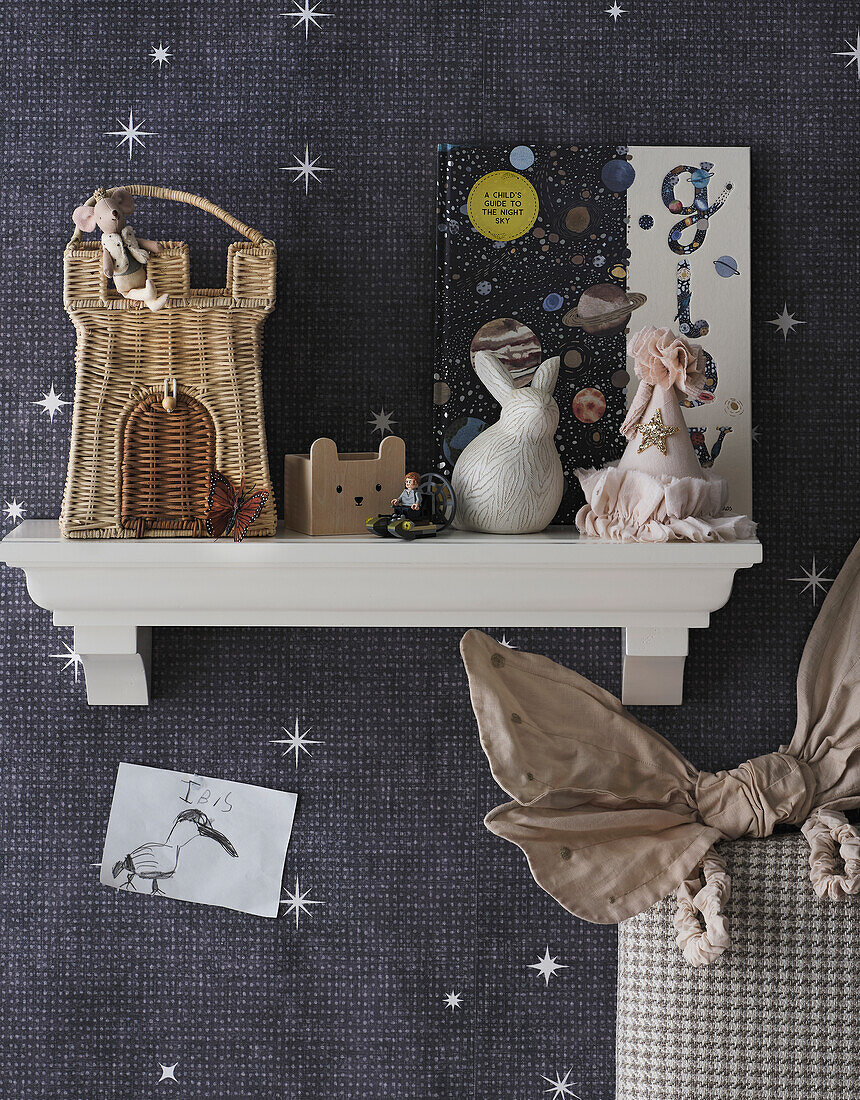 Playful children's room shelf with decorations and night motif wallpaper