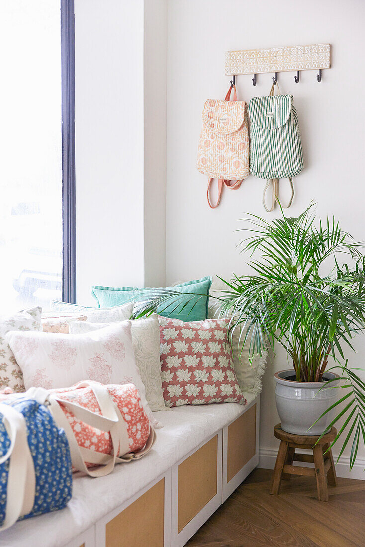 Light-coloured cushions and bags with block print patterns on a white bench