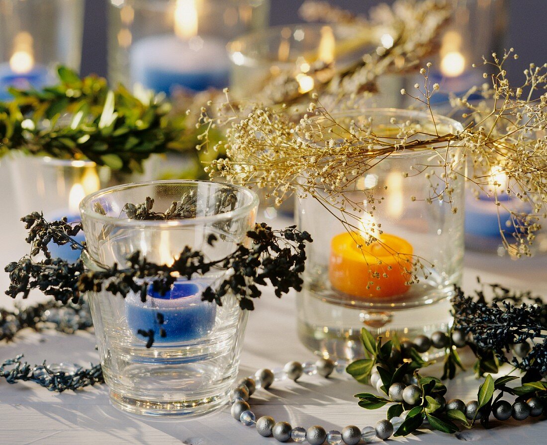 Teelichter mit weihnachtlichen Zweigen als Tischdeko