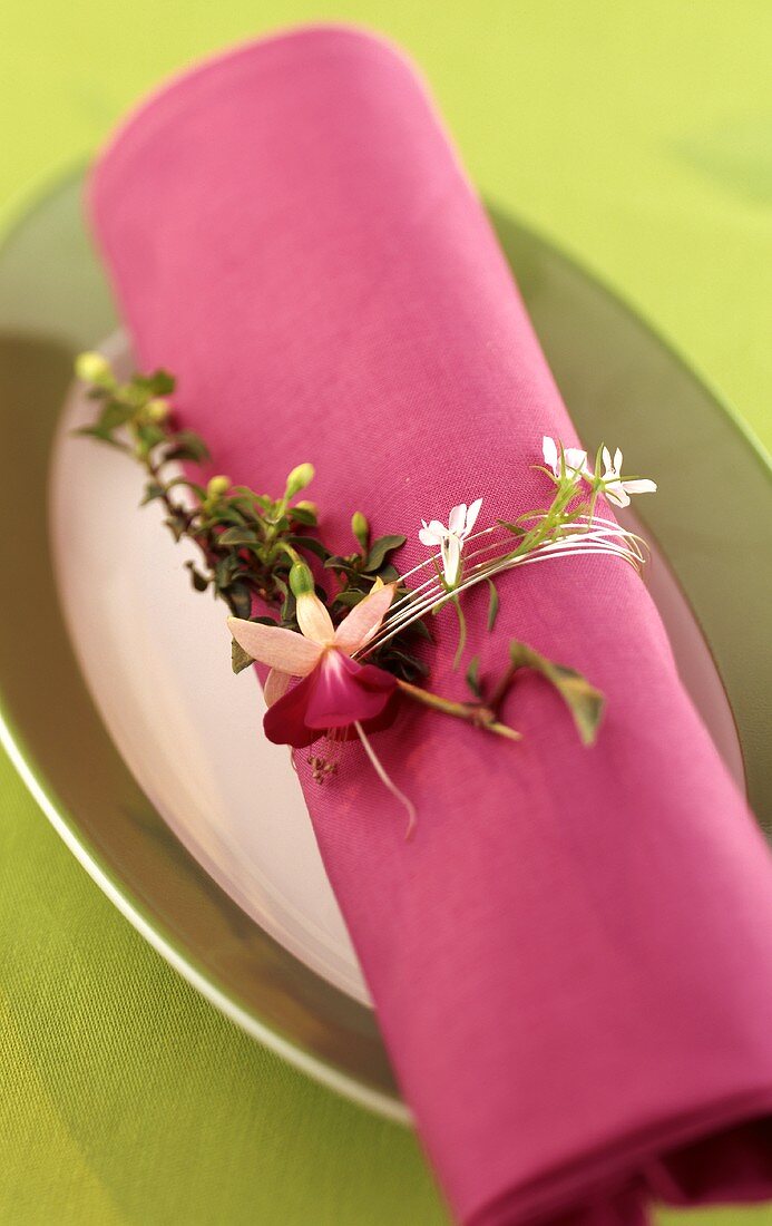 Serviettenring aus Silberdraht & Blüten um violette Serviette