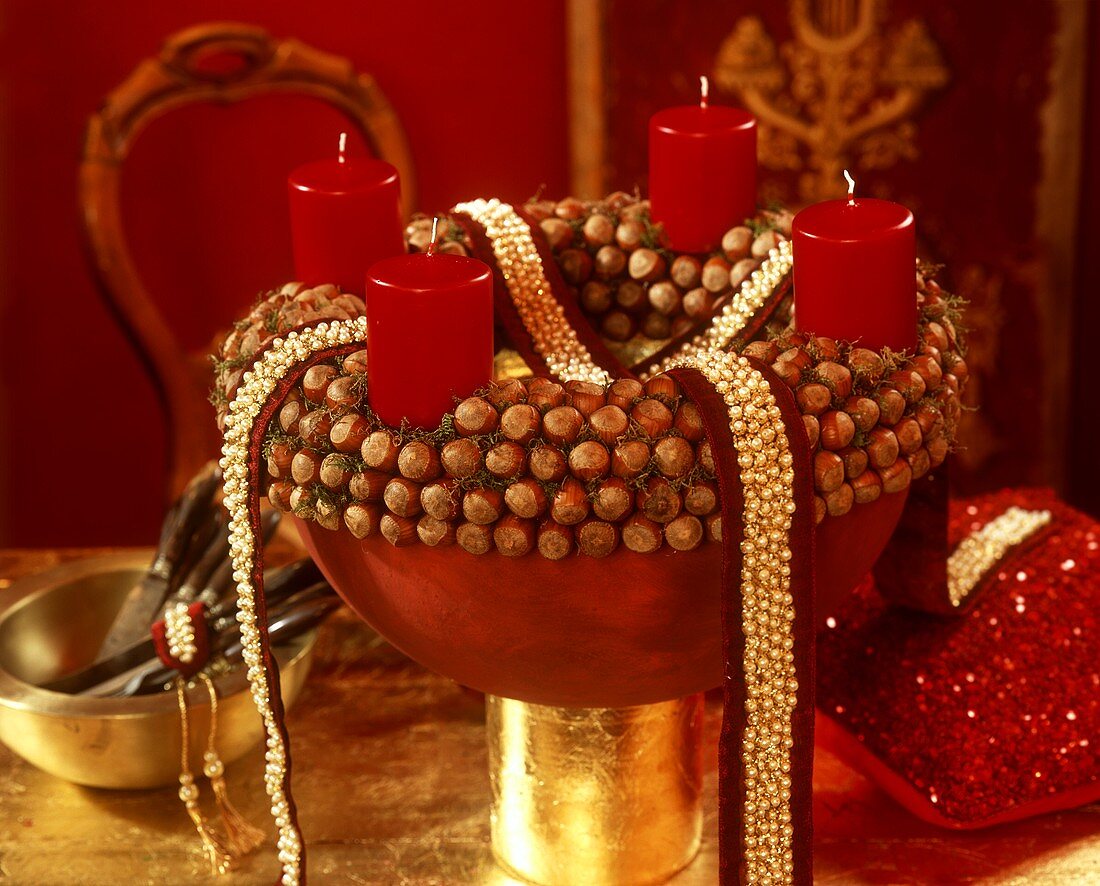 Adventskranz aus Haselnüssen mit vier brennenden Kerzen