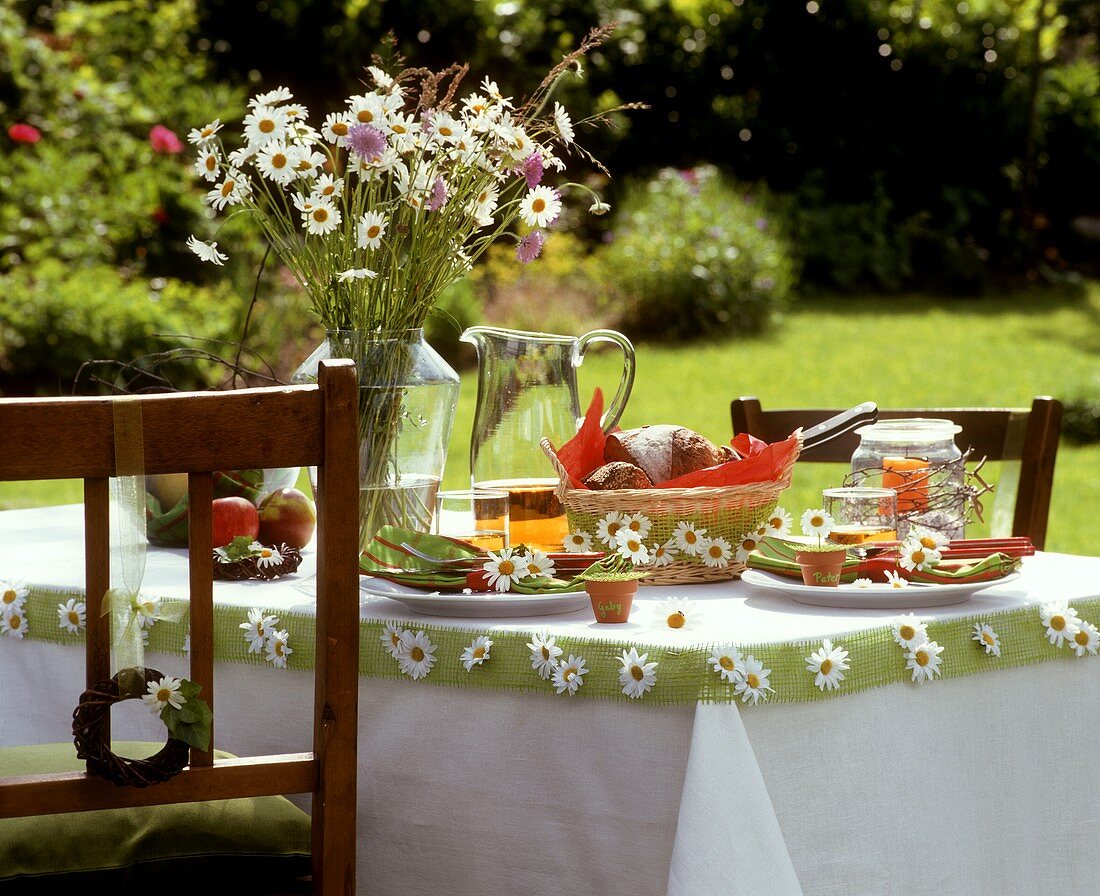 Mit Margeriten dekorierter Tisch im Garten