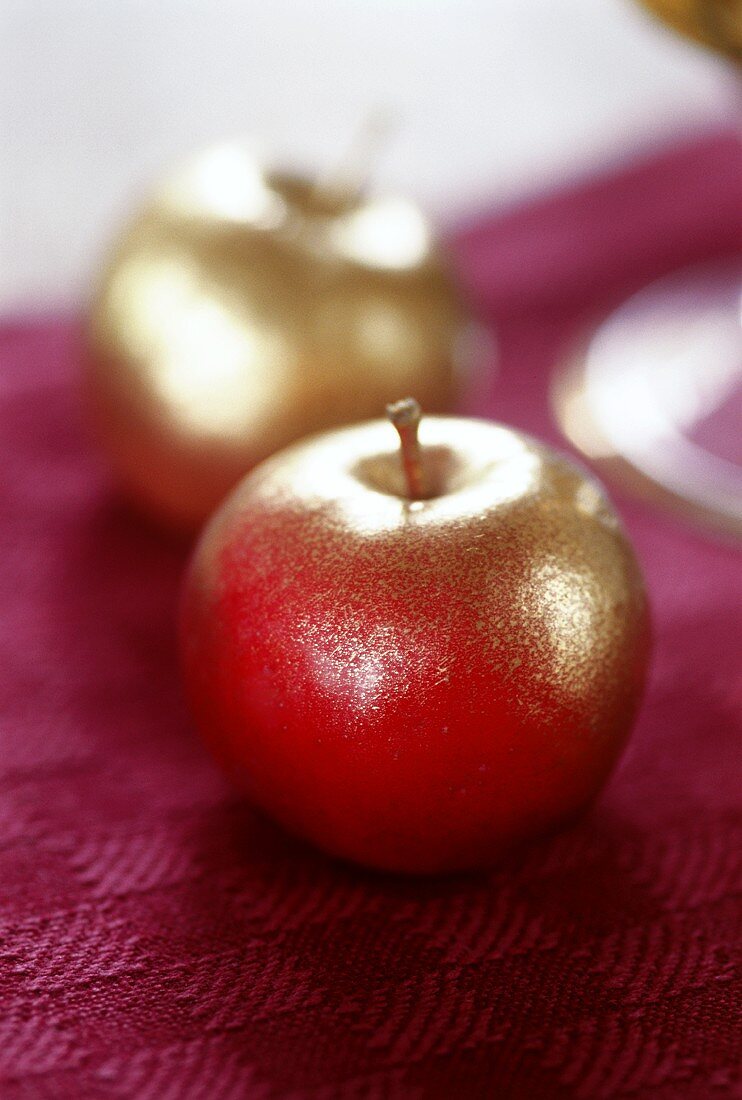 Zwei vergoldete Äpfel als Tischdeko