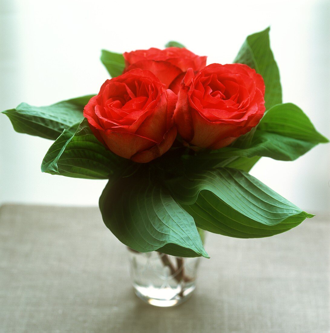 Kleiner Blumenstrauss mit drei roten Rosen