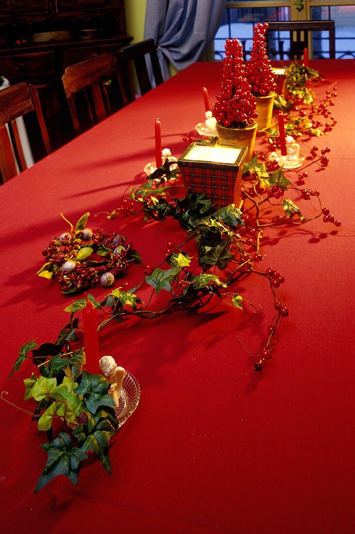 Weihnachtliche Tischdekoration mit Efeu und Hagebutten
