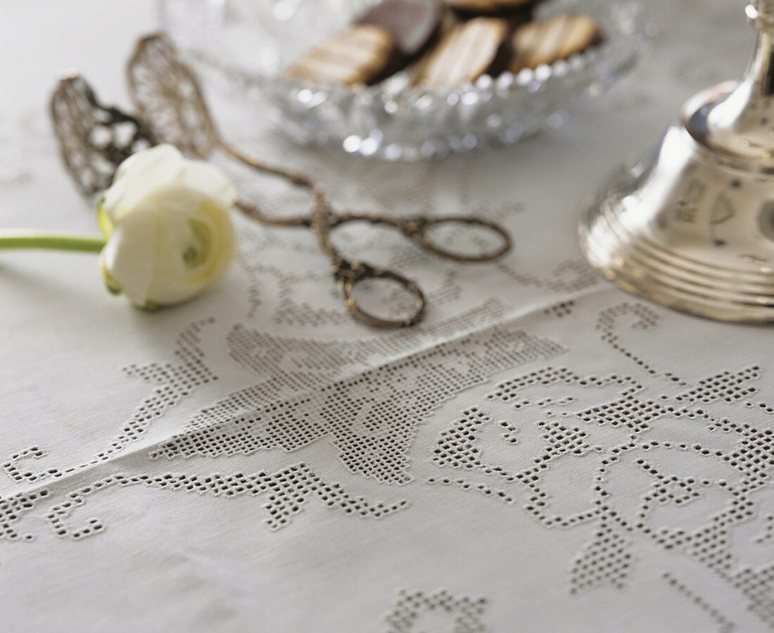 White hemstitch tablecloth with ranunculus and cake tongues