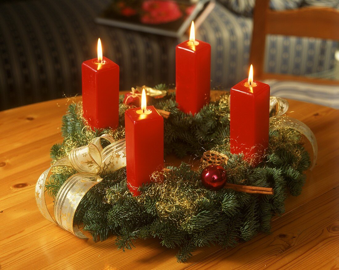 Adventskranz mit vier brennenden roten Kerzen