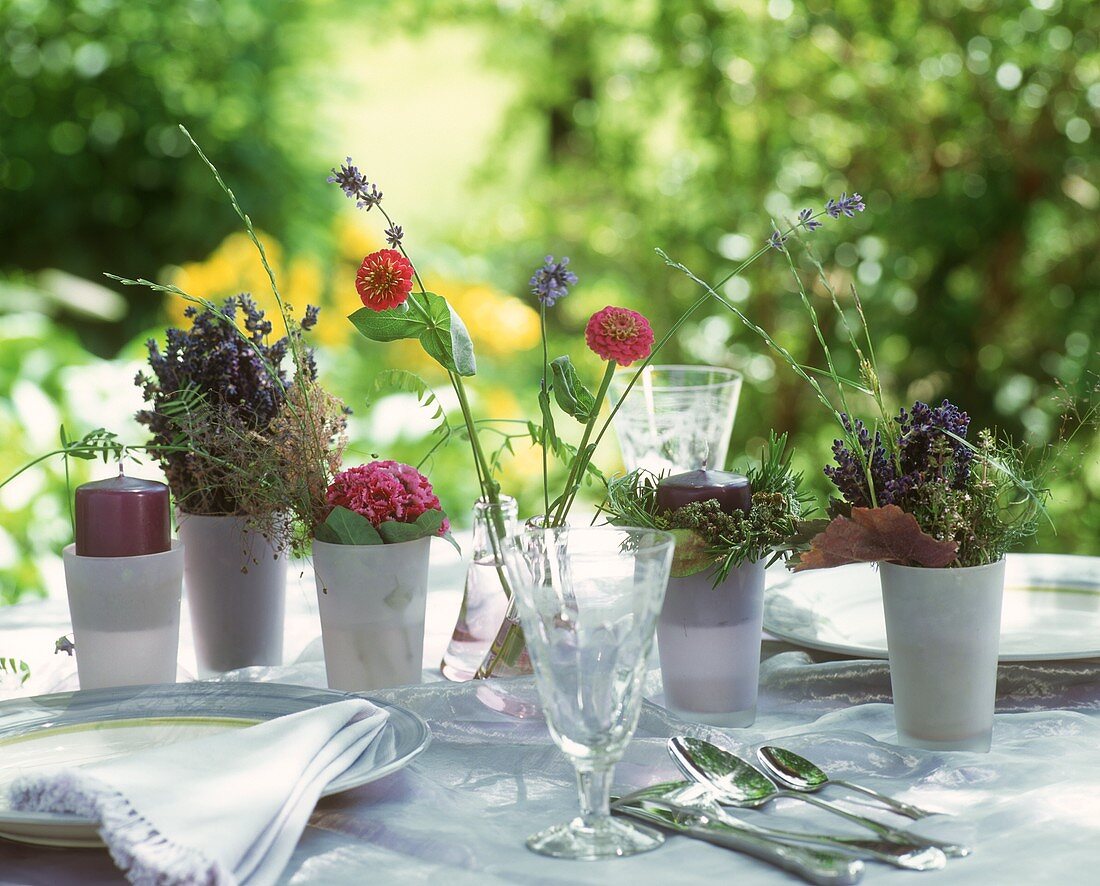 In zarten violett-Tönen gedeckter Tisch auf Gartenterrasse