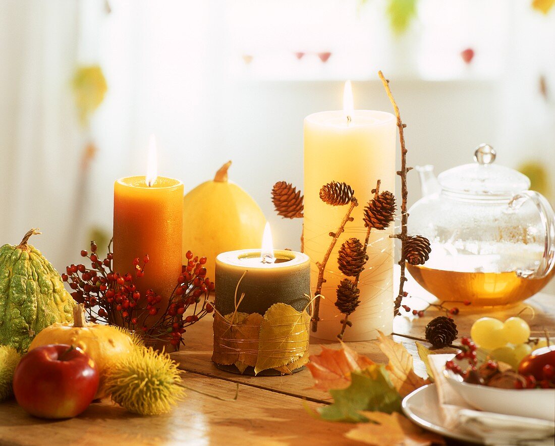 Autumn or winter table decoration with candles, tea, etc.