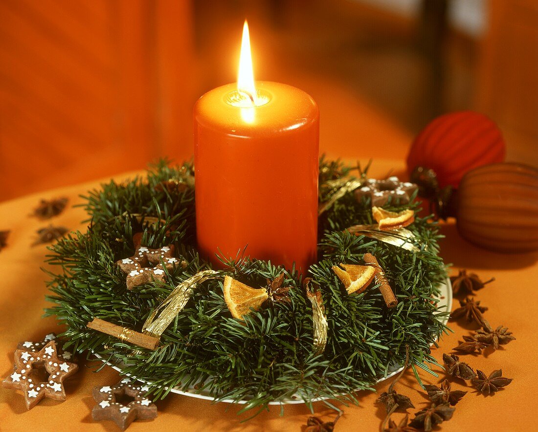Kleiner Adventskranz mit orangefarbener Kerze