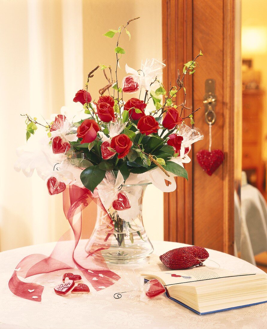 Romantic bouquet of roses, decorated with hearts, in vase