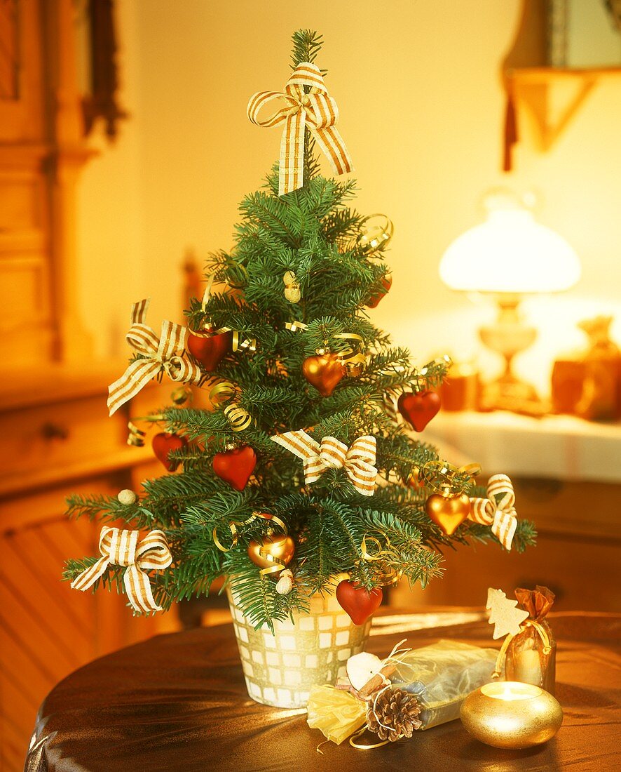Small Christmas tree and sack of presents on a table