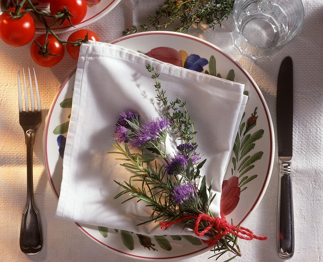 Plate with napkin and bunch of herbs