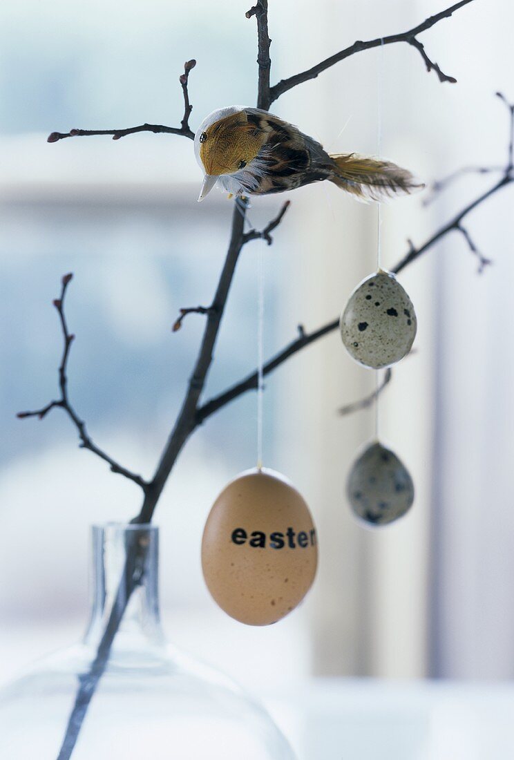 Osterdeko: Zweig mit Eiern und Vogel
