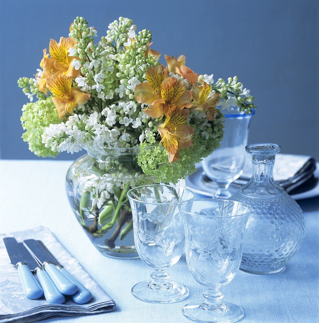 Gedeckter Tisch mit Frühlingsstrauss und eleganten Gläsern