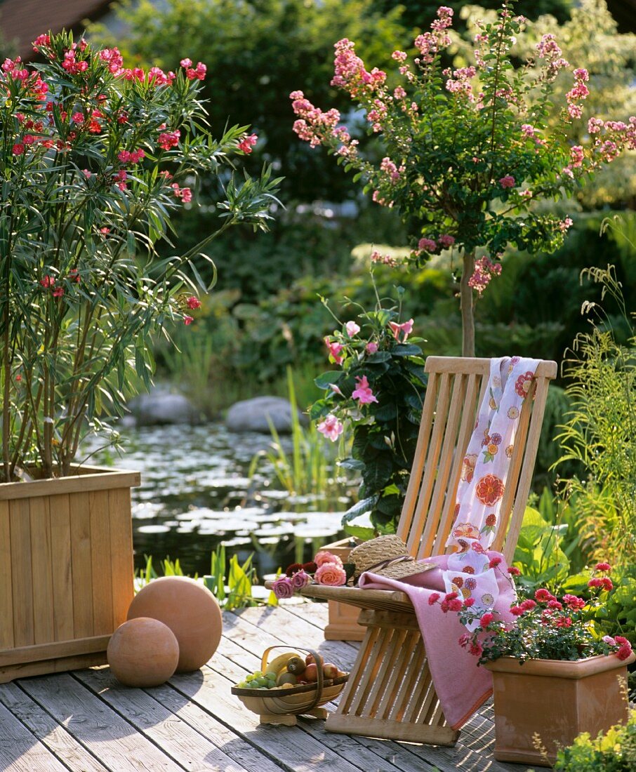 Wooden chair on terrace by garden pond